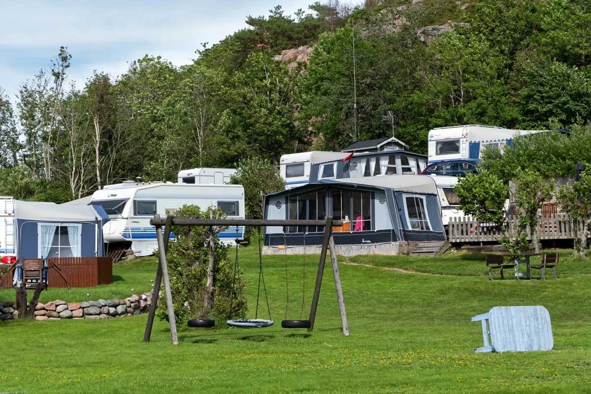 Caravans parked side by side at a grassy campground